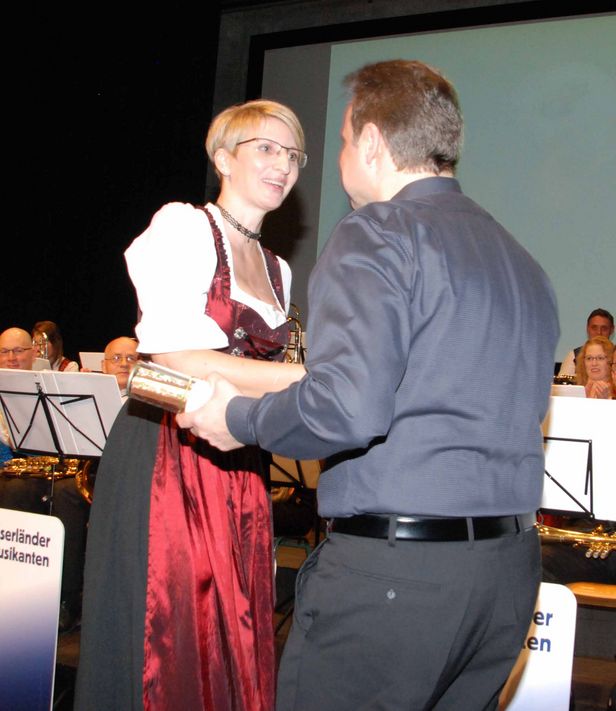 Präsidentin Moni Jud überreicht Dirigent Patrick Gründler für seine grosse Arbeit ein Präsent.