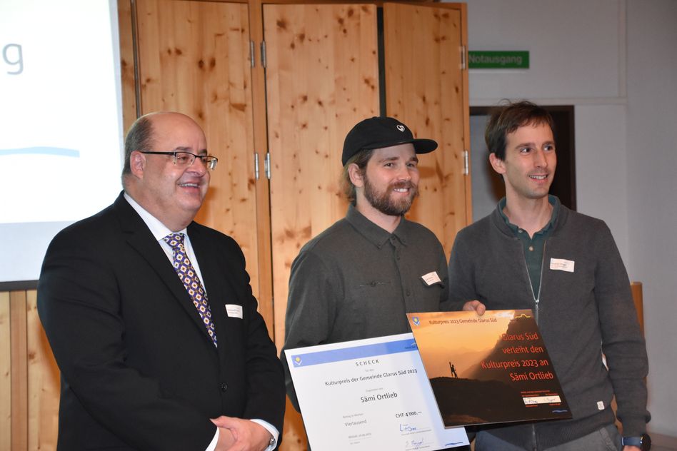 Sämi Ortlieb, der Kulturpreisgewinner von Glarus Süd (Mitte) wird von Gemeindepräsident Hans-Rudolf Forrer (links) und Gemeinderat Stephan Mugg (rechts) ausgezeichnet (Bilder: e.huber)