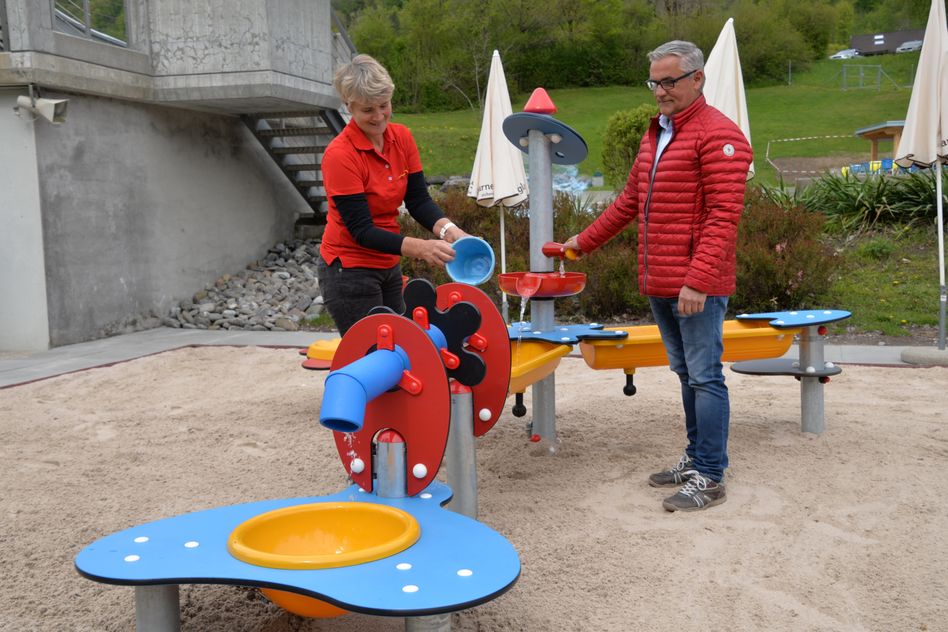 Uschi Bürge, Bademeisterin, und Werner Rhyner, Departementsleiter Gesellschaft und Sicherheit Glarus Süd, präsentieren das neue Wasserspiel in der Badi Schwanden (Bilder: e.huber)
