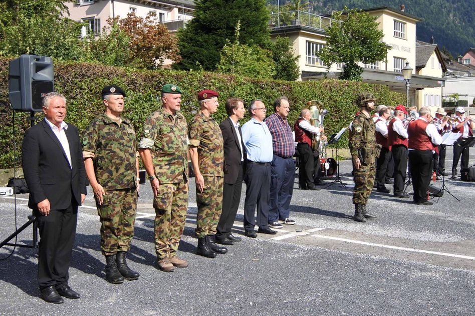 Landammann Andrea Bettiga und weitere militärische Vertreter beim Abspielen der Schweizer Nationalhymne