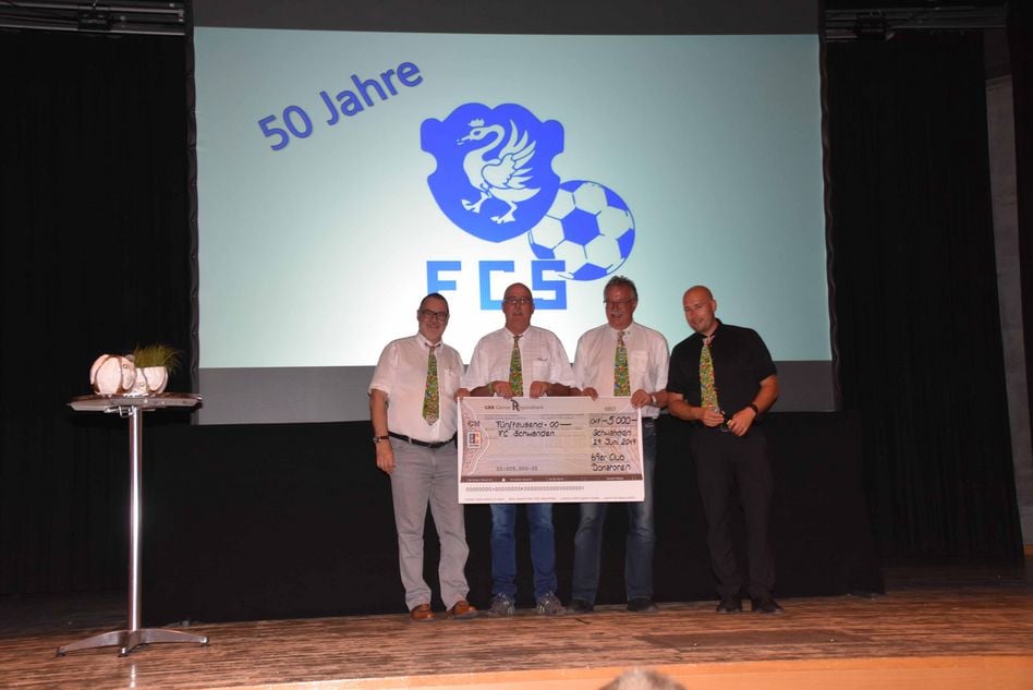 Die Donatoren des FC Schwanden übergeben dem FCPräsident Jacques Marti einen Check über 5.000 Franken-