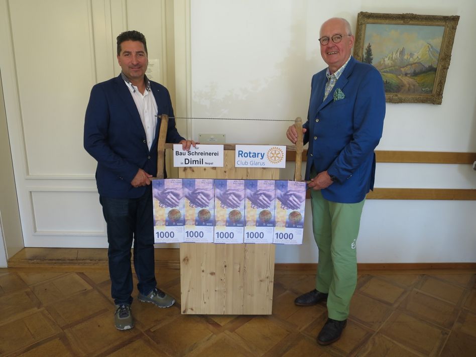 Rotary Präsident 2024/2025 Rolf Kohler (links) übergibt mit Säge als Symbol die Spende an Michael Ladwig, dem unermüdlichen Förderer von Dimil. (Bild: zvg)
