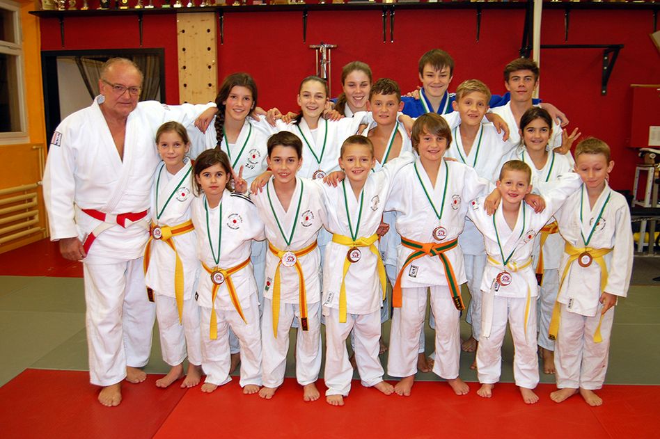 Trainer Mimmo Nicoletti (6. Meistergrad) mit seinen erfolgreichen Schülerinnen und Schülern, im Dojo Niederunen. (Bild: zvg)