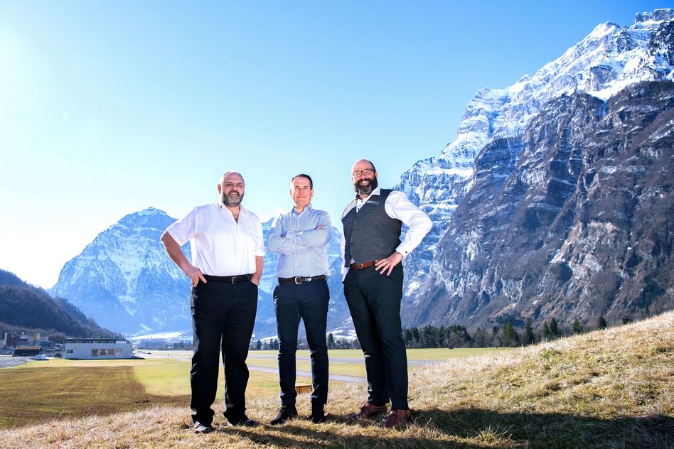 Hansruedi Hauser (Pr sident Tr gerverein, links), Patric Deflorin und Jakob Kamm umrahmt von der Naturarena, die Heimat des ESAF 2025 Glarnerland+ ist.