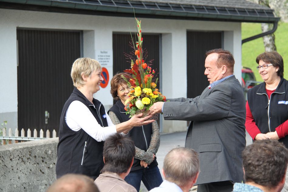 VR-Präsident Alex Rüegg überreicht dem Ladenteam die verdienten Blumen.