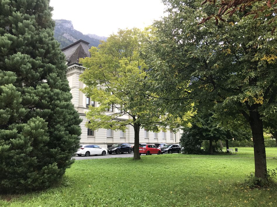 Angestellte der Gemeindeverwaltung dürfen seit dem 1. August 2023 nicht mehr im Gemeindehauspark Ennenda parkieren – für alle anderen ist die Grünanlage nach wie vor ein Parkplatz. (Bild: SP Glarus)