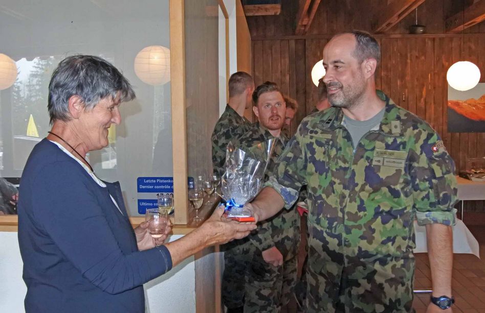 Bataillonskommandant Oberstlt i Gst Ralf Walser überreicht Dorfführerin Anna Brühwiler ein Präsent