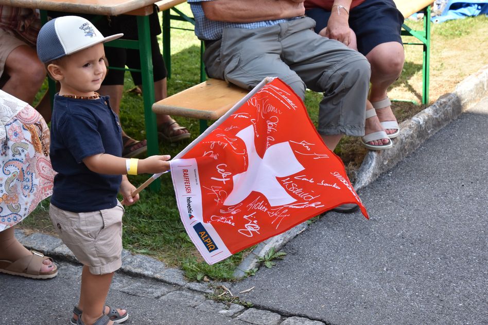 Der fröhliche Knabe schwingt eine ganz besondere Schweizerfahne