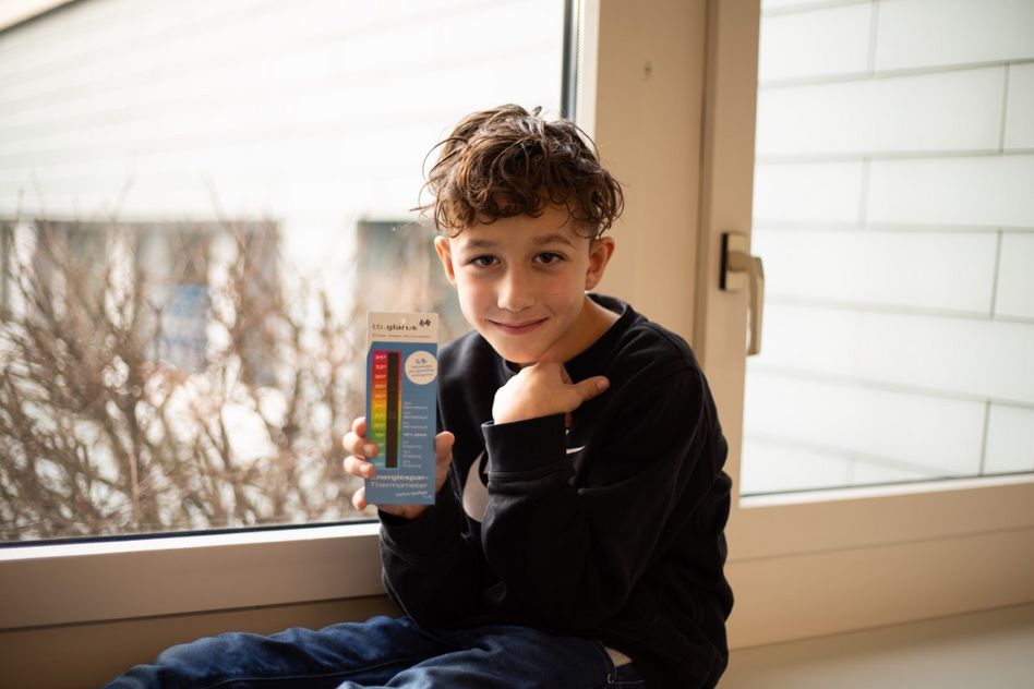 : Kind am Fenster mit Energiespar-Thermometer*** (Bilder: zvg)