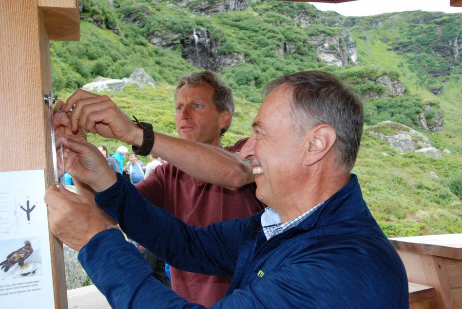 Die Auszeichnung mit dem „Label Schweizer Holz“ auf Plexiglas wird in einer Gemeinschafts-produktion von Gemeindepräsident This Vögeli und Bauleiter Markus Brunner montiert